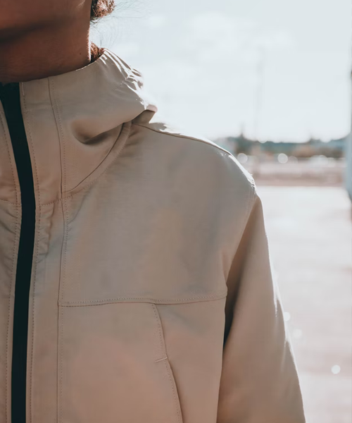 en kvinna i en beige jacka